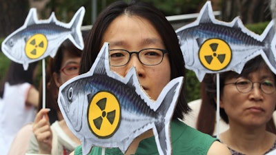 In this file photo, environmentalists stage a rally denouncing imported agricultural and marine products from Japan.