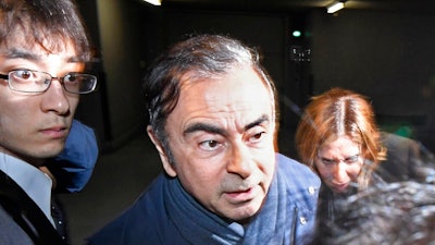 In this Wednesday, April 3, 2019, file photo, former Nissan Chairman Carlos Ghosn, center, leaves his lawyer's office in Tokyo. Tokyo prosecutors arrested Ghosn on Thursday, April 4, 2019 for a fourth time on fresh allegations that cut short his brief time outside detention.