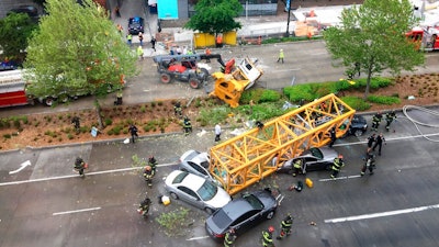 Fire and police crew members work to clear the scene where a construction crane fell from a building on Google's new Seattle campus crashing down onto one of the city's busiest streets and killing multiple people on Saturday, April 27, 2019.