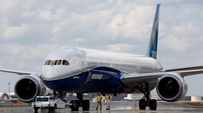 In this file photo Boeing employees walk the new Boeing 787-10 Dreamliner down towards the delivery ramp area at the company's facility in South Carolina. Singapore Airlines says it has grounded two of its Boeing 787-10 aircraft due to engine issues.