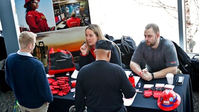 In this March 7, 2019, file photo visitors to the Pittsburgh veterans job fair meet with recruiters at Heinz Field in Pittsburgh.