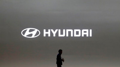 In this March 28, 2019, file photo a journalist passes by the logo of Hyundai Motor during a media preview of the Seoul Motor Show in Goyang, South Korea. Hyundai has found a new problem that can cause its car engines to fail or catch fire, issuing yet another recall to fix problems that have affected more than 6 million vehicles since 2015.