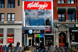 In this Dec. 14, 2017, file photo people bike and walk by Kellogg's NYC Cafe at Union Square in New York. Kellogg is selling its iconic Keebler cookie brand and other sweet snacks businesses to Ferrero for $1.3 billion.