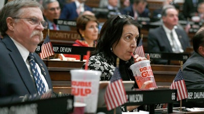 In this Feb. 20, 2019 file photo, state Rep. Anne Dauphinais R-Killingly, takes a sip from a big gulp soda as Connecticut Democrat Gov. Ned Lamont delivers his budget address at the State Capitol in Hartford, Conn. Lamont proposed a tax on sugary drinks in his first budget. Connecticut is among several states likely to see debate this year over taxes that advocates endorse as way to reduce consumption of liquid calories. On March 25 the American Academy of Pediatrics and the American Heart Association called for education campaigns and raising prices through taxes to reduce consumption of sugary drinks by young people.