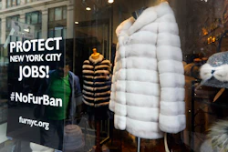 This April 10, 2019, photo shows a sign by furnyc.org in the window of Victoria Stass Collection in New York's fur district. The fur trade is considered so important to New York’s development that two beavers adorn the city’s official seal, a reference to early Dutch and English settlers who traded in beaver pelts.