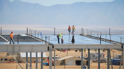 In this Nov. 14, 2017, file photo, construction workers build one of the Facebook data center buildings in Los Lunas, N.M. A powerful regulatory authority in New Mexico decided Tuesday, April 16, 2019, it is requiring the state's largest utility to bill Facebook $39 million for the construction of a new transmission line, a move that the social media giant says could affect its long-term operations in the state.