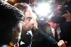 In this April 3, 2019, photo, former Nissan Chairman Carlos Ghosn, center, mobbed by journalists leaves his lawyer's office in Tokyo. Japanese prosecutors took Ghosn for questioning Thursday, April 4, 2019, barely a month after he was released on bail ahead of his trial on financial misconduct charges.