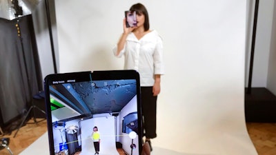 In this April 16, 2019, file photo, a model holds a Samsung Galaxy Fold smart phone to her face, during a media preview event in London. Samsung is pushing back this week's planned public launch of its highly anticipated folding phone after reports that reviewers' phones were breaking. The company had been planning to release the Galaxy Fold on Friday. Instead, it says it will to run more tests and announce a new launch date in the coming weeks.