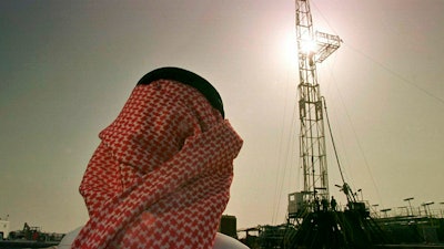 In this file photo, Khaled al-Otaiby, an official of the Saudi oil company Aramco, watches progress at a rig at the al-Howta oil field near Howta, Saudi Arabia.