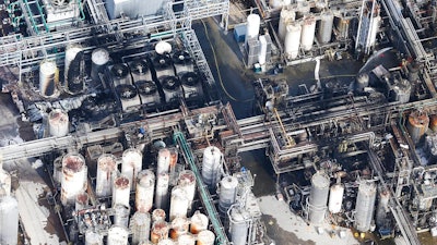 This aerial photo shows firefighters spraying water on a fire at the KMCO chemical plant on Tuesday, April 2, 2019 in Crosby, Texas. Authorities say the fire has been contained at the plant near Houston and they have lifted an order that instructed residents within a 1-mile (1.6 kilometers) radius of the facility to stay indoors.