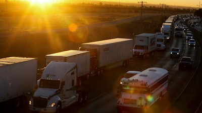 A row of trucks wait to cross the border with the United States in Ciudad Juarez, Mexico. The Trump administration has reassigned so many inspectors from U.S.-Mexico border crossings that it has caused huge traffic backups.