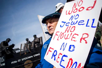 Genesee County Clerk-Register John Gleason protests alongside a dedicated handful United Auto Workers retirees during a protest against former UAW 1-C Director Norwood Jewell, Tuesday, April 2, 2019 at Sitdowners Memorial Park in Flint, Mich. Jewell is expected to enter a plea agreement Tuesday, on charges related to misuse of union workers' training funds. The retired UAW workers who protested are asking for all mentions of Jewell's name to be removed from the park.