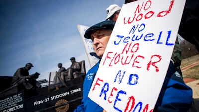 Genesee County Clerk-Register John Gleason protests alongside a dedicated handful United Auto Workers retirees during a protest against former UAW 1-C Director Norwood Jewell, Tuesday, April 2, 2019 at Sitdowners Memorial Park in Flint, Mich. Jewell is expected to enter a plea agreement Tuesday, on charges related to misuse of union workers' training funds. The retired UAW workers who protested are asking for all mentions of Jewell's name to be removed from the park.