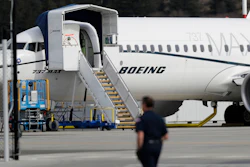In this March 14, 2019, file photo, a worker walks next to a Boeing 737 MAX 8 airplane parked at Boeing Field in Seattle. U.S. aviation regulators said Monday, April 1, Boeing needs more time to finish changes in a flight-control system suspected of playing a role in two deadly crashes.