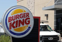 In this Thursday, April 25, 2019, photo a customer takes his order from the drive through window at a Burger King in Redwood City, Calif. Restaurant Brands International, the parent company of Burger King and Tim Hortons, reports financial results on Monday, April 29.