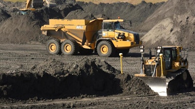 In this Nov. 14, 2017 file photo, crews with Duke Energy continue to remove coal ash from the old coal ponds at the Sutton Plant, in Wilmington, N.C. Duke Energy Corp., the country’s largest electric company, was ordered Monday, April 1, 2019 to excavate coal ash from all of its North Carolina power plant sites, slashing the risk of toxic chemicals leaking into water supplies but potentially adding billions of dollars to the costs consumers pay.