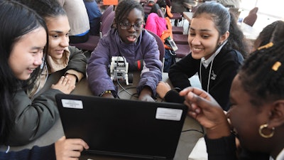 In this file photo taken Feb. 21, 2019, seventh grade students from Grace Academy in Hartford, Conn., work together on a robot using plans on a computer at the Connecticut Science Center in Hartford. Though less likely to study in a formal technology or engineering course, America's girls are showing more mastery of those subjects than their boy classmates, according to newly released national education data made public Tuesday, April 30, 2019.