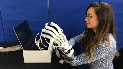 Alexandra Lindsay, a junior scientist at UTARI, displays the rehab glove.