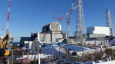 In this Jan. 25, 2018, file photo, an installation of a dome-shaped rooftop cover housing key equipment is near completion at Unit 3 reactor of the Fukushima Dai-ich nuclear power plant ahead of a fuel removal from its storage pool in Okuma, Fukushima Prefecture, northeast Japan. Japan has partially lifted an evacuation order in one of the two hometowns of the tsunami-wrecked Fukushima nuclear plant for the first time since the 2011 disaster. The action taken Wednesday, April 10, 2019, allows people to return about 40 percent of Okuma. The other hometown, Futaba, remains off-limits as are several other towns nearby.