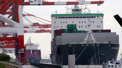 In this June 18, 2018, file photo, a container ship, right, arrives at a container terminal in Tokyo. The latest surveys of Japanese manufacturers are pointing to a slowdown for the world’s third-largest economy. The Bank of Japan’s quarterly “tankan” survey of major manufacturers on Monday showed a deterioration in confidence in March compared with December.