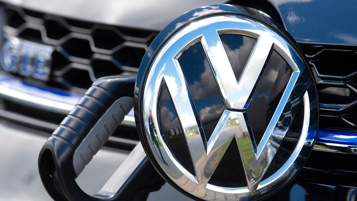 In this Tuesday, May 14, 2019 photo an e-Golf car is fixed with a charging station during a press tour at the plant of the German manufacturer Volkswagen AG (VW) in Zwickau, Germany. Volkswagen will total shift into electric cars at the plant in Zwickau and the first vehicles are to roll off the assembly line at the end of 2019.