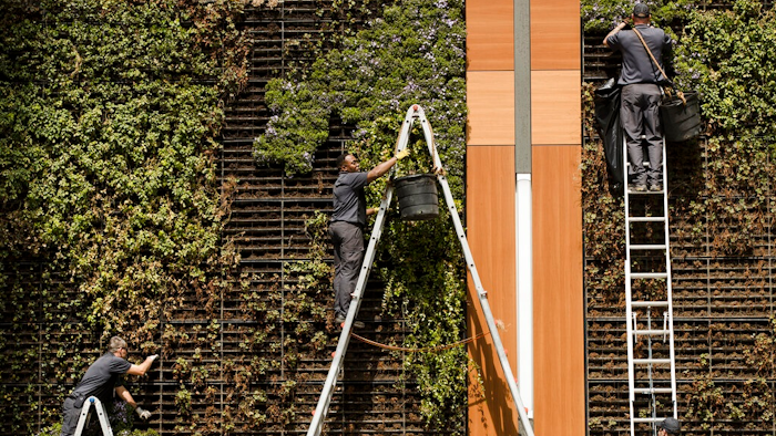 In this April 9, 2019, photo gardeners work on a vertical planters in Philadelphia. On Tuesday, April 30, the Labor Department releases the employment cost index for the first quarter, a measure of wage and benefit growth.