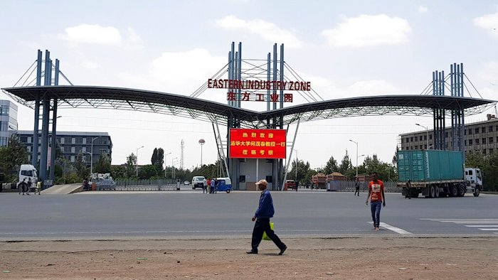In this March 21, 2018 file photo, people walk past the gate of the Eastern Industrial Zone in Ethiopia in the town of Dukem near the capital, Addis Ababa. Ethiopian garment factory workers are now, on average, the lowest paid in any major garment-producing company worldwide, a new report said Tuesday, May 7, 2019.