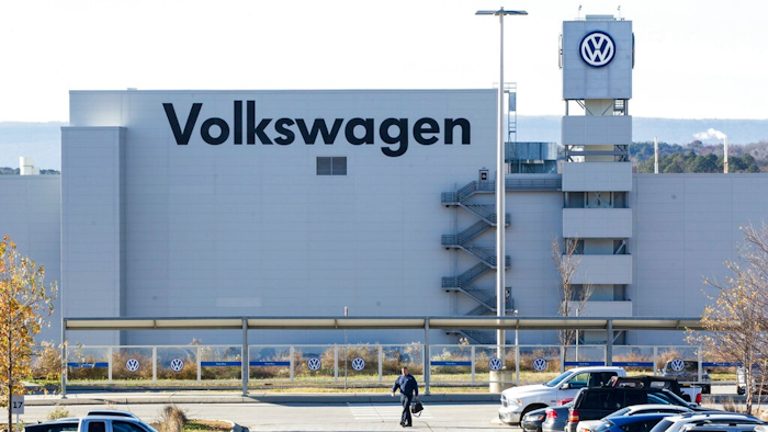 In this Dec. 4, 2015, file photo, a man walks through the employee parking lot at the Volkswagen plant in Chattanooga, Tenn. In a split decision, the National Labor Relations Board on Wednesday, May 22, 2019, has ruled in favor of Volkswagen in a setback for unionization efforts at its Chattanooga, Tennessee, plant. The NRLB has dismissed a petition for a union vote by the United Auto Workers based on a technicality. The union intends to refile immediately.