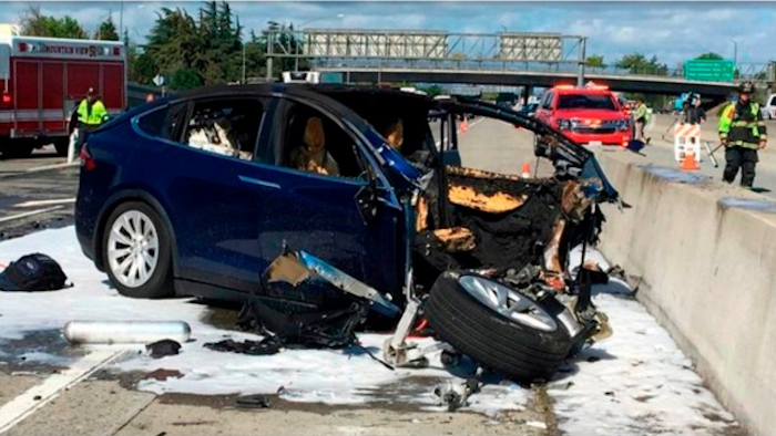 In this March 23, 2018, file photo provided by KTVU, emergency personnel work at the scene where a Tesla electric SUV crashed into a barrier on U.S. Highway 101 in Mountain View, Calif. Federal investigators say the Tesla using the company’s semi-autonomous driving system accelerated just before crashing into a California freeway barrier, killing its driver. The National Transportation Safety Board issued a preliminary report on the crash on Thursday, June 7.