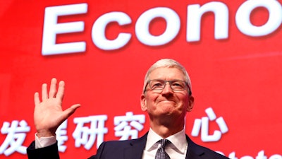 In this Saturday, March 23, 2019, file photo, Apple CEO Tim Cook waves as he arrives for the Economic Summit held for the China Development Forum in Beijing, China. Few U.S. companies are more vulnerable to a trade war with China than Apple. The company relies on factories in China to assemble the iPhones that generate most of its profits; it has also cultivated a loyal following in the country.
