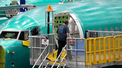 This March 27, 2019, file photo shows a Boeing 737 MAX 8 airplane on the assembly line during a brief media tour of Boeing's 737 assembly facility in Renton, Wash. Recent crashes have caused an uptick in airline fatalities in 2018 and 2019 after a long trend of safer flying. Boeing 737 Max accidents have raised concern over the ability of all pilots to handle automation. Still, aviation deaths are down sharply from the 1990s, and experts credit advances in aircraft and airport design, better air traffic control, and more pilot training.
