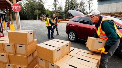 In this Monday, April 11, 2016 file photo, New Hampshire state and local officials load boxes of free bottled water in in Litchfield, N.H. New Hampshire is suing eight companies including 3M and Dupont for damage it says has been caused statewide by a class of potentially toxic chemicals found in everything from pizza boxes to fast-food wrappers. The state becomes the second in the nation to go after the makers of perfluoroalkyl and polyfluoroalkyl substances or PFAS and the first to target statewide contamination.