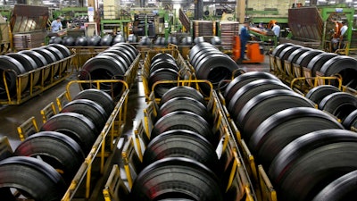 In this April 28, 2019, photo, workers assemble truck's tires at a plant in Nantong city in east China's Jiangsu province Sunday, April 28, 2019. China's exports fell in April amid a bruising tariff war with Washington, adding to pressure on Beijing on the eve of negotiations aimed at settling the fight over its technology ambitions.