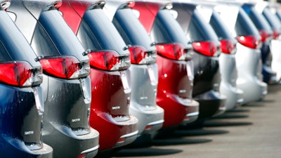 In this April 15, 2018, file photo, unsold 2018 Pacifica minivans sit on a Chrysler dealer's lot in the south Denver suburb of Englewood, Colo. Fiat Chrysler is recalling over 208,000 minivans in North America because they could lose power-assisted steering or engines can stall. The recall covers certain Chrysler Pacifica minivans from the 2017 through 2019 model years. All have systems that stop the engine for traffic lights and restart it when a driver presses the gas pedal.