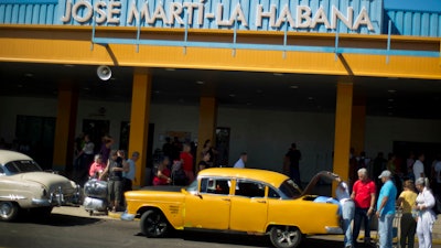 In this Sept. 1, 2014 file photo, people put their luggage in a private taxi as they arrive from the U.S. to the Jose Marti International Airport in Havana, Cuba. In 1958, the father of José Ramón López owned Cuba's main airport, its national airline and three small hotels. All were taken in Cuba's socialist revolution. Starting Thursday, they will be able to file lawsuits against European and American companies doing business on their former properties, thanks to the Trump administration's decision to activate a provision of the U.S. embargo on Cuba with the potential to affect foreign investment in Cuba for many years to come.