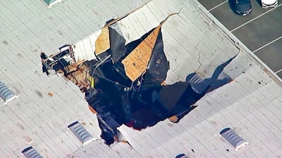 This photo taken from video provided by KABC-TV shows where an F-16 fighter jet crashed into a warehouse just outside March Air Reserve Base in Riverside, Calif., Thursday afternoon, May 16, 2019. Maj. Perry Covington, director of public affairs at the base, says the pilot ejected before the crash and was not hurt and there are no immediate reports of injuries on the ground.
