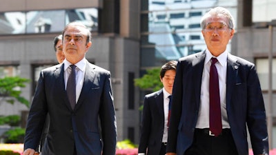 Former Nissan chairman Carlos Ghosn, left, accompanied by his lawyer Junichiro Hironaka, arrives at Tokyo District Court for a pre-trial meeting in Tokyo Thursday, May 23, 2019. Ghosn, who is out on bail, has been charged with under-reporting his post-retirement compensation and breach of trust in diverting Nissan money and allegedly having it shoulder his personal investment losses.