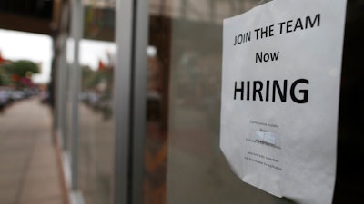 In this July 18, 2018, file photo a 'now hiring' sign hangs in the window of a Chinese restaurant in downtown Fargo, N.D. Small business hiring is slowing, according to numbers released by payroll provider ADP.