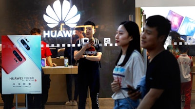 In this Monday, May 20, 2019, photo, shoppers visit a Huawei store in Beijing. Chinese tech giant Huawei has filed a motion in U.S. court challenging the constitutionality of a law that limits its sales of telecom equipment.
