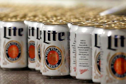 In this March 11, 2015 file photo, newly-filled and sealed cans of Miller Lite beer move along on a conveyor belt, at the MillerCoors Brewery, in Golden, Colo. A Wisconsin judge on Friday, May 24, 2019, ordered Anheuser-Busch to stop suggesting in advertising that MillerCoors' light beers contain corn syrup, wading into a fight between two beer giants that are losing market share to small independent brewers.