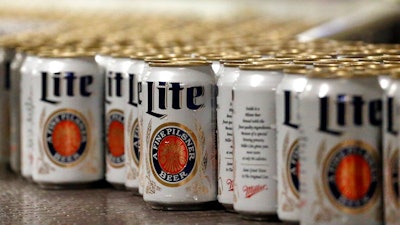 In this March 11, 2015 file photo, newly-filled and sealed cans of Miller Lite beer move along on a conveyor belt, at the MillerCoors Brewery, in Golden, Colo. A Wisconsin judge on Friday, May 24, 2019, ordered Anheuser-Busch to stop suggesting in advertising that MillerCoors' light beers contain corn syrup, wading into a fight between two beer giants that are losing market share to small independent brewers.