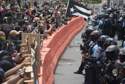 Demonstrators holding wooden shields are confronted by police during a protest against the Federal Fiscal Control Board, as part of the May Day celebration in San Juan, Puerto Rico, Wednesday, May 1, 2019. The U.S. Congress established the appointed Fiscal Control Board to oversee the debt restructuring in order to combat the Puerto Rican government-debt crisis.