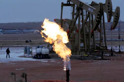 In this Oct. 22, 2015 file photo, workers tend to oil pump jacks behind a natural gas flare near Watford City, N.D. Natural gas is being burned off and wasted at record levels in North Dakota because development of the pipelines and processing facilities needed to handle it has not kept pace. Natural gas production hit a record in March. But about 20 percent of it went up in flames through “flaring,” the process of burning off the gas when it can’t be captured.