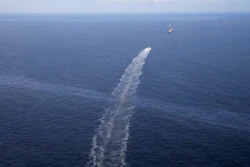 In this March 31, 2015 file photo, the wake of a supply vessel heading towards a working platform crosses over an oil sheen drifting from the site of the former Taylor Energy oil rig in the Gulf of Mexico, off the coast of Louisiana. The Coast Guard says a newly installed containment system is collecting oil at the site of the 14-year-old oil leak in the Gulf of Mexico. A Coast Guard statement Thursday, May 16, 2019, describes the installation of the subsea containment system as a “major milestone” in the federal government’s long-running efforts to contain the leak.