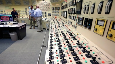 Senior Reactor Operator Christina Renaud, left, speaks with Training Supervisor Paul Gresh, center, and Control Room Supervisor Bob Sheridan, right, in the Control Room Simulator moments before a simulated reactor shutdown, Tuesday, May 28, 2019, at a training facility several miles from the Pilgrim Nuclear Power Station, in Plymouth, Mass. The simulated shutdown was performed in front of members of the media Tuesday ahead of the planned actual shutdown of the aging reactor on Friday, May 31.