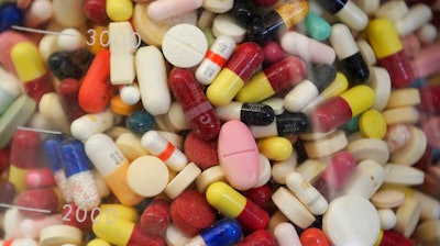 This July 6, 2017 file photo shows prescription drugs in a glass flask at the state crime lab in Taylorsville, Utah. Attorneys general from more than 40 states are alleging the nation's largest generic drug manufacturers conspired to artificially inflate and manipulate prices for more than 100 different generic drugs, including treatments for diabetes, cancer, arthritis and other medical conditions. The lawsuit, filed in federal court Friday, May 10, 2019 also names 15 individual senior executives responsible for sales, marketing and pricing.