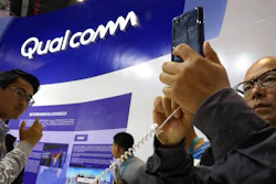 In this Nov. 6, 2018 file photo, attendees look at the latest technology from Qualcomm at the China International Import Expo in Shanghai. Qualcomm’s stock is tumbling before Wednesday’s market open on May 22, 2019, after a federal judge ruled that the company unlawfully stifled cellphone chip market competition and charged excessive licensing fees.