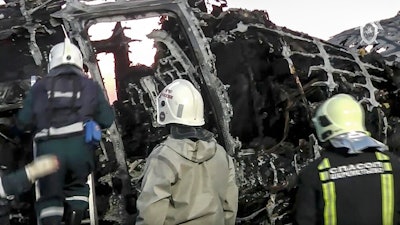 This image taken from a video distributed by Russian Investigative Committee on Monday, May 6, 2019, shows employees of the Russian Emergency Situations work at the wreckage of Sukhoi SSJ100 aircraft of Aeroflot Airlines in Sheremetyevo airport, outside Moscow. A Russian airliner burst into flames while making an emergency landing at Moscow's Sheremetyevo airport Sunday evening, and at least 40 people died, officials said.
