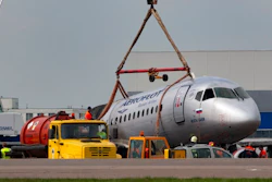 A crane lifts the damaged Sukhoi SSJ100 aircraft of Aeroflot Airlines in Sheremetyevo airport, outside Moscow, Russia, Monday, May 6, 2019. Russian emergency workers have recovered 41 bodies and two flight recorders from the wreckage of the plane that caught fire during an emergency landing in Moscow, officials said Monday as they sought to discover the cause of the disaster.