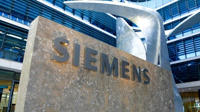 This June 24, 2016 file photo shows the logo of German industrial conglomerate Siemens at the new headquarters in Munich, Germany. German industrial equipment maker Siemens said Tuesday May 7, 2019, it will cut some 10,000 jobs in a major restructuring that will involve spinning off its oil, gas and power generation business and creating new areas of growth.